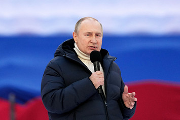 Vladimir Putin is pictured holding a microphone