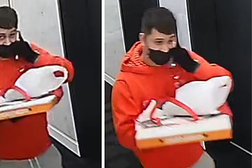 A suspect holding a pizza box