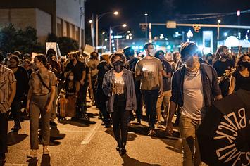 People march in the street after a vigil for Garrett Foster on July 26, 2020