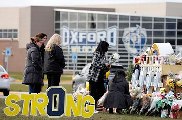 People gather at the memorial for the dead and wounded outside of Oxford High School in Oxford, Michigan