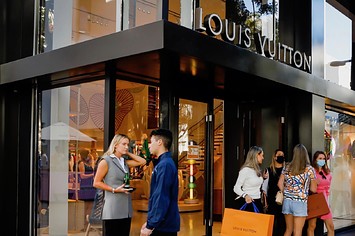 Shoppers exit the Louis Vuitton store in Miami, Florida