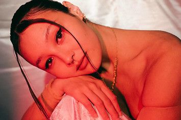 Luna Li sitting in front of a pink sheet