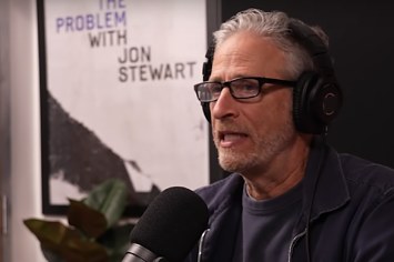 Jon Stewart speaks into a microphone