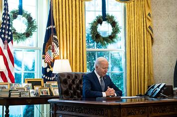 Joe Biden sits in the Oval Office