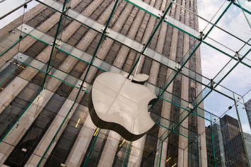 An Apple logo is pictured in a city environment