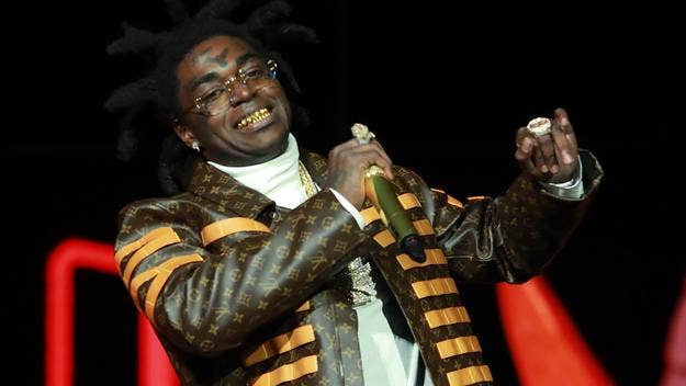 The social media back-and-forth kicked off when Kodak Black posted a photo showing him tying DreamDoll’s shoes on Instagram on Valentine's Day.