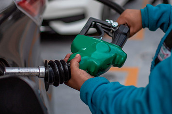 Attendant fills up the tank of a car.