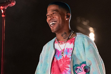 Kid Cudi is pictured smiling during a live show