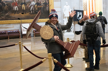 A pro-Trump protester carries the lectern of U.S. Speaker of the House Nancy Pelosi through the Roturnda of the U.S. Capitol Building