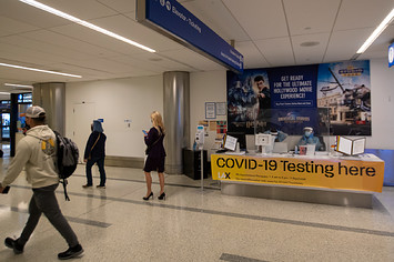 Travelers are shown walking by a testing center
