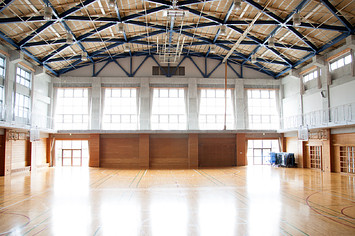 An empty school gymnasium. Basketball court markings.