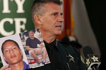 Sheriff John W. Mina shows photos of Armando Manuel Caballero during a press conference.