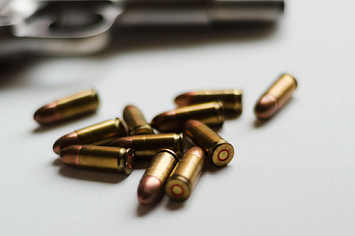 Image of a gun and bullets on table