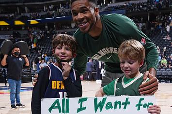 Giannis Antetokounmpo gives his autographed sneakers to a young fan after a game against the Denver Nuggets