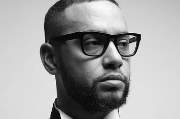 Director X poses in a white shirt and x-shaped tie