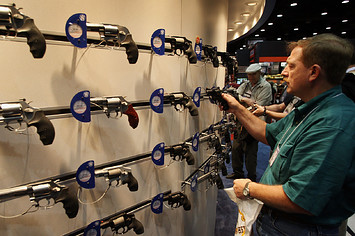 Tim Basington looks over Smith & Wesson pistols at the NRA annual meeting.