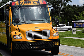 A school bus drives past Pershing School in Orlando. Students in all Orange County schools