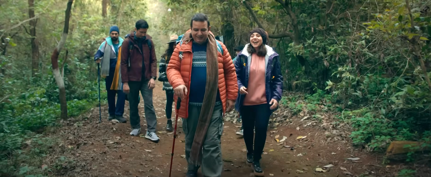 A family of five walking through a forest