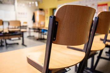 Chairs are placed on the tables in a classroom in a primary school.