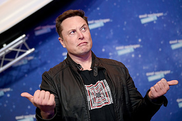 Elon Musk gestures as he arrives on the red carpet for the Axel Springer Awards ceremony