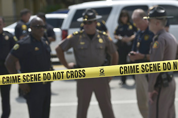 Police stand behind a crime scene tape