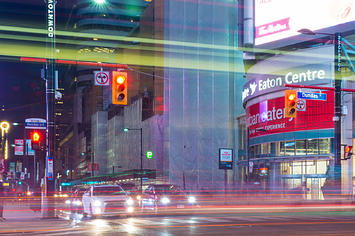 Dundas Square long exposure looking south, Evening city with bright lights and advertising signs on buildings.