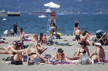 People enjoy their leisure time under the hot weather warning at Kitsilano Beach in Vancouver, Canada,