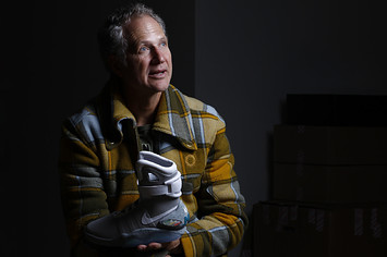 Nike designer Tinker Hatfield holding the Back to the Future Nike Mag shoes he designed
