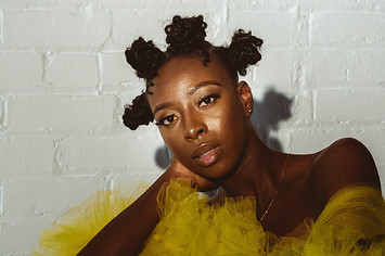 Singer Zenesoul posing in a yellow tulle gown
