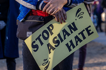 A person holds a sign during the "Asian Solidarity March" rally.