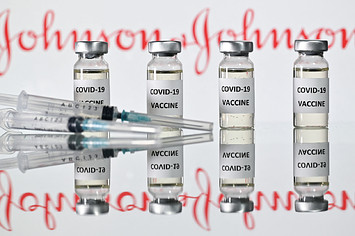 Illustration shows vials with Covid-19 Vaccine stickers with Johnson & Johnson logo.