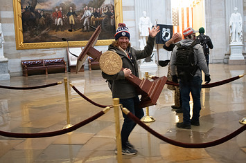 Man holding Nancy Pelosi’s lectern in Capitol riots