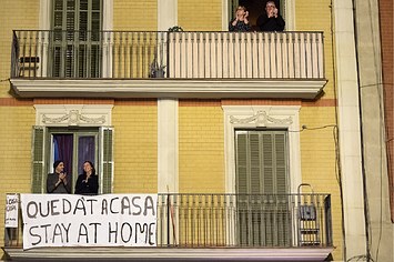 Spanish people sit on balconies during COVID 19 lockdown
