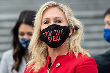 Marjorie Taylor Greene holds up a "Stop the Steal" mask.