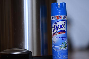 Lysol disinfectant spray next to a trash can