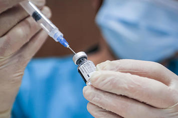 A health worker prepares a dose of Pfizer/BioNTech coronavirus (COVID 19) vaccine.