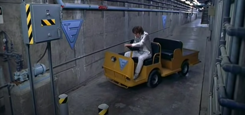 A man attempts a three point turn in an impossibly tiny car