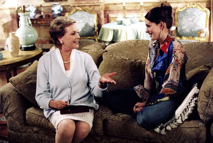 Julie Andrews and Anne Hathaway on a couch smiling at each other