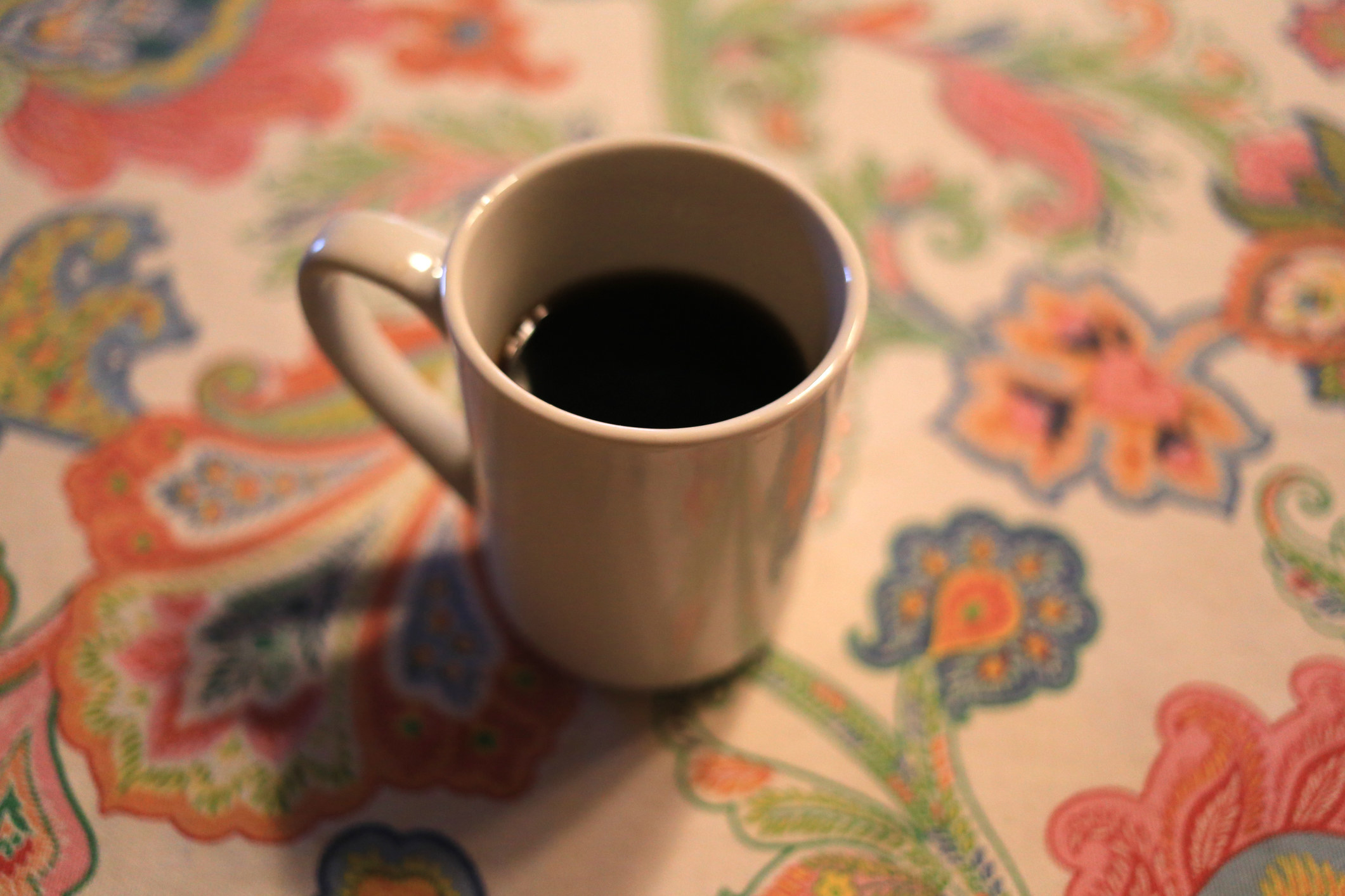 A mug of coffee on a table.