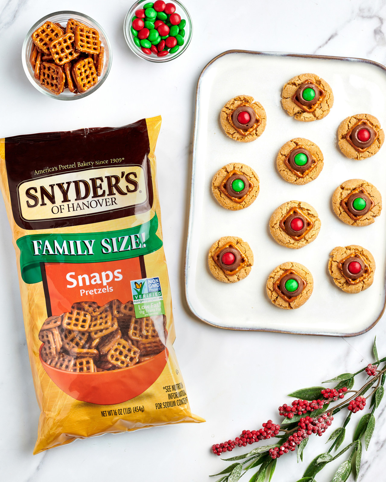 Pretzel snaps cookies on baking tray beside a bag of pretzel snaps