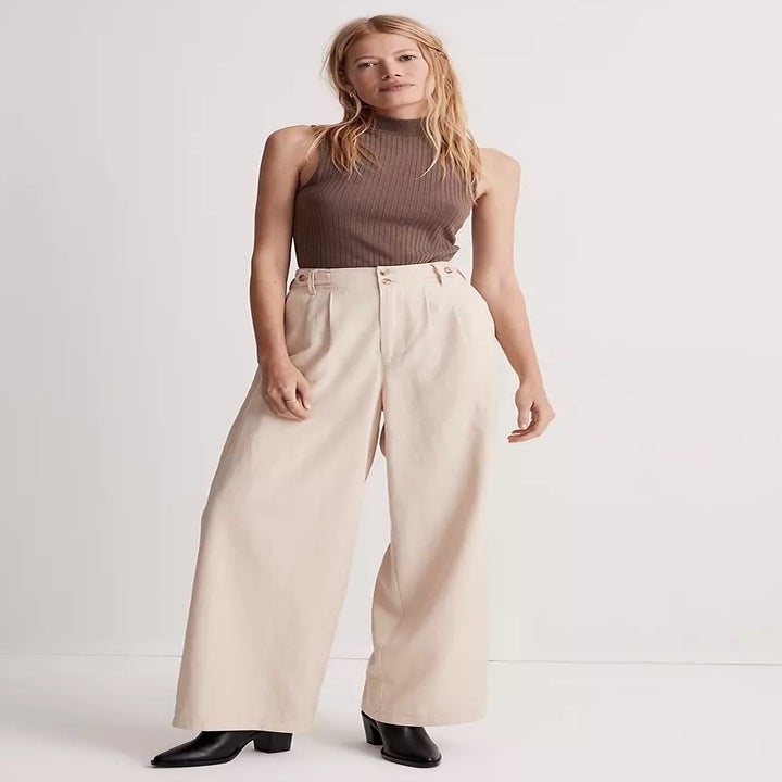 model in cream wide-legged trousers