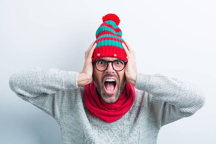 A man screaming with hands over his ears