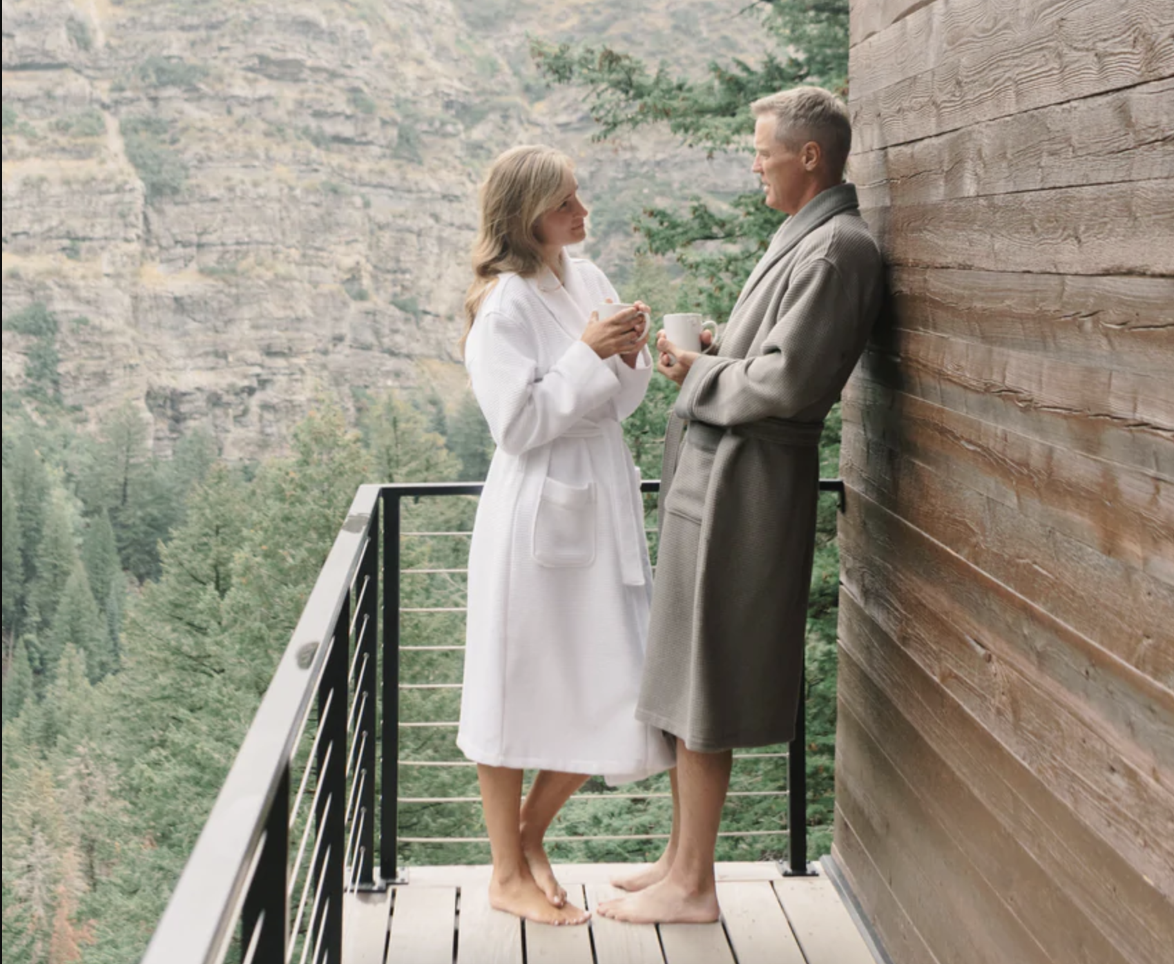 Two people wearing the robes stand outside on a balcony