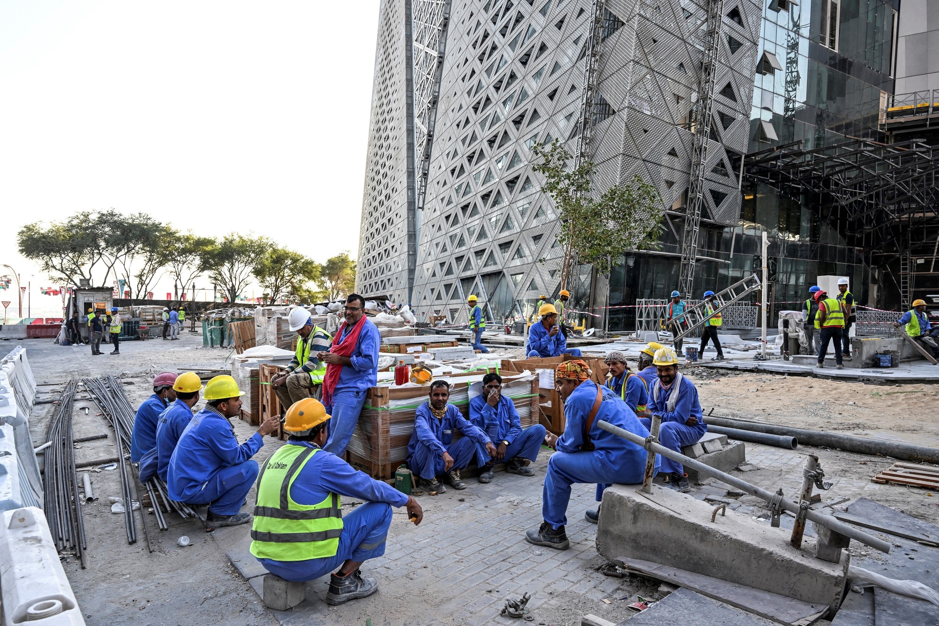 Workers sitting outside the venue under construction