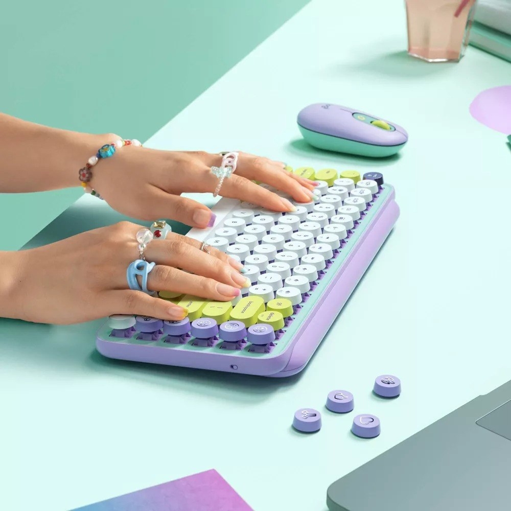 the pastel colored keyboard with hands typing on it