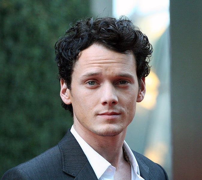 Anton Yelchin in a suit looking at the camera
