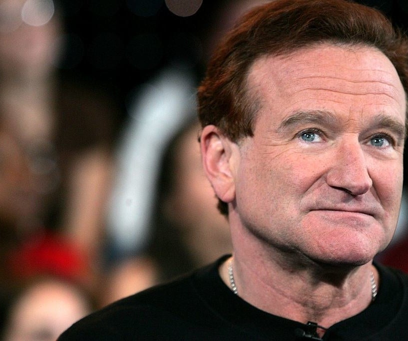 Robin Williams on a red carpet, looking up