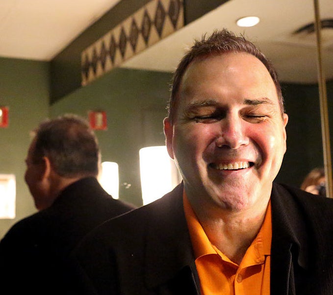 Norm sitting in a green room, smiling