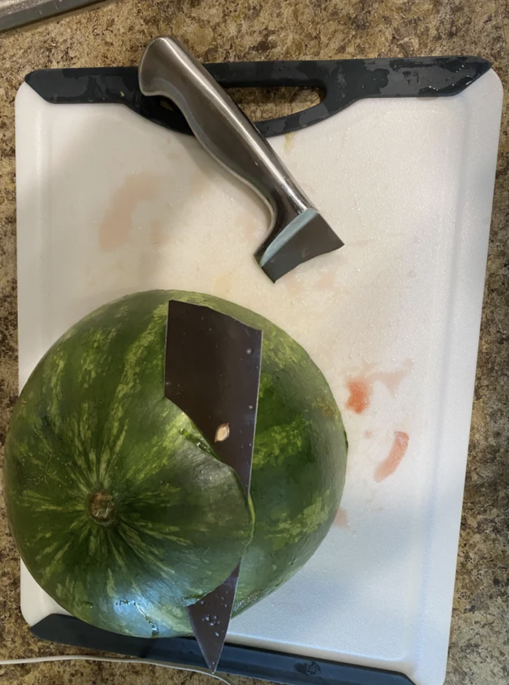 A knife blade stuck in a watermelon