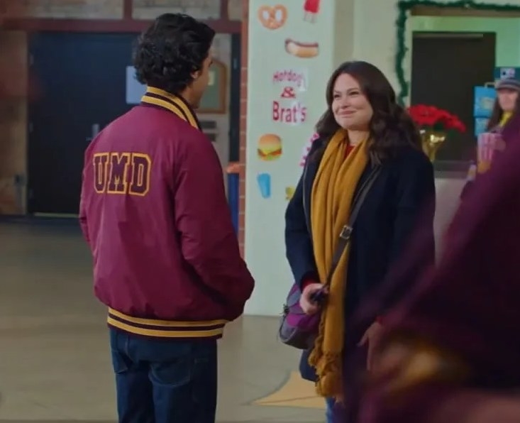 Hesse Bradford and Katie Lowes talk to each other while wearing sports team attire